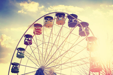 Retro vintage stylized picture of ferris wheel at sunset.