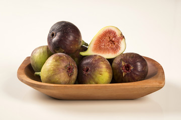 A couple of figs in a pot over a wooden table