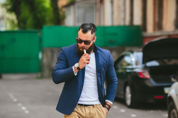 man with a beard smokes electronic cigarette