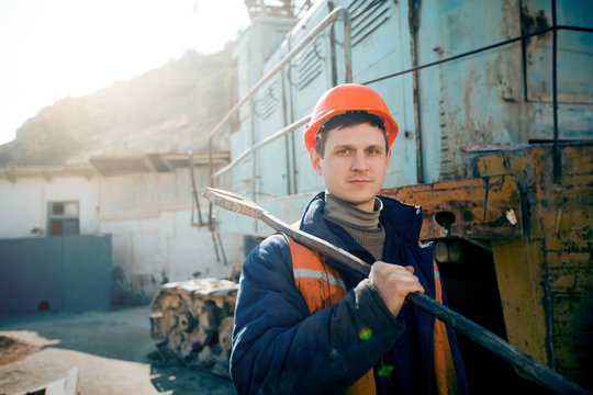 Portrait worker in helmet standing with a hammer on the shoulder