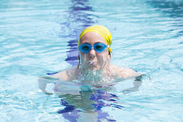 young girl having fun swimming underwater in the pool