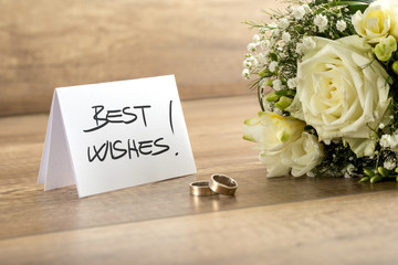 Wedding Flowers, Rings and Card on Wooden Table
