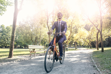 Smiling businessman riding a bike