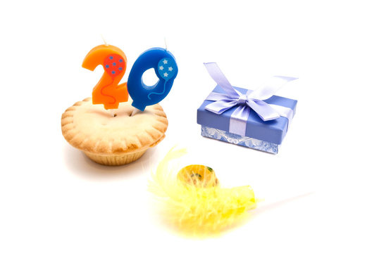 cupcake with twenty years birthday candle, gift and whistle