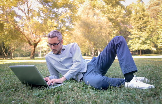 Man using a laptop at the park