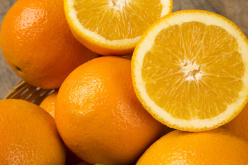 Close up of some oranges in a basket over a wooden surface