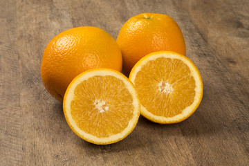 Close up of some oranges in a basket over a wooden surface