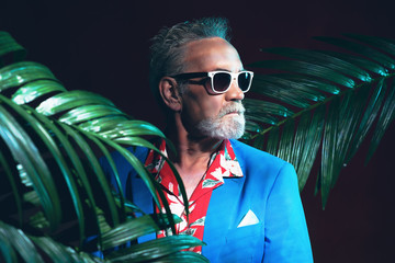 Businessman Between Palms Looking into Distance