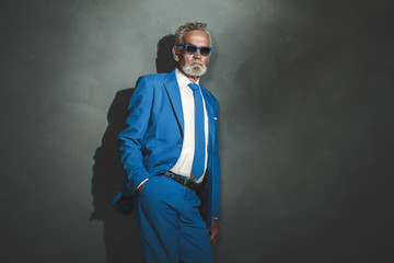 Businessman with Sunglasses Leaning Against Wall