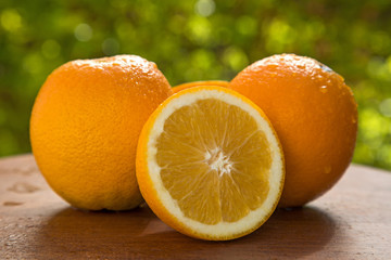 Close up of some oranges in a basket over a wooden surface