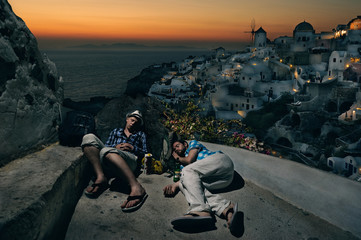 Tourists with backpacks sleeping at the Oia village