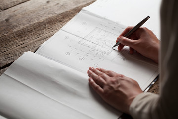 woman holding a pen over a house blueprint