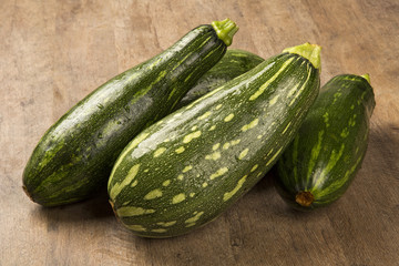 Some zucchinis over a white wooden surface