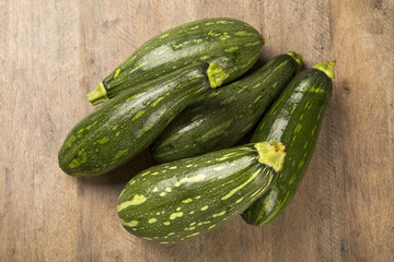 Some zucchinis over a white wooden surface