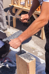 Worker produces roofing slate using a  slate hammer