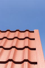 Red metal tile against blue sky