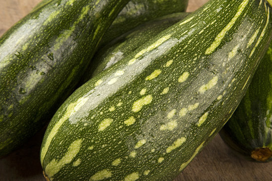 Some zucchinis over a white wooden surface