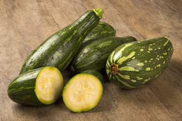 Some zucchinis over a white wooden surface