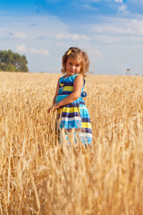 Portrait of the little girl in a wheat field