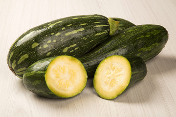 Some zucchinis over a white wooden surface