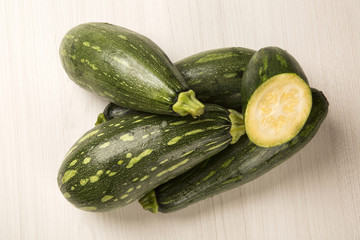 Some zucchinis over a white wooden surface