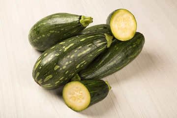 Some zucchinis over a white wooden surface