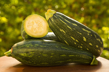 Some zucchinis over a white wooden surface