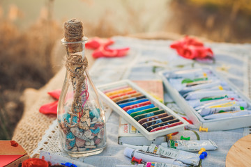 Colorful crayons, acrylic paints and bottle with wishes