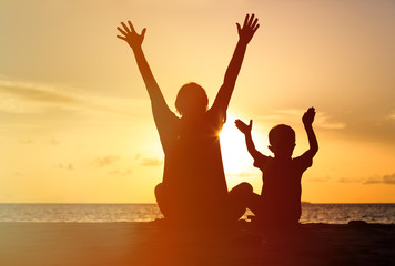 Fototapeta premium Silhouette of happy father and son at sunset