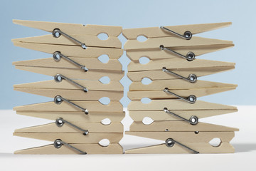 Clothes pegs forming a "wall" on white floor and blue background