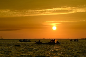 Naklejka na ściany i meble Boat on sea during sunset