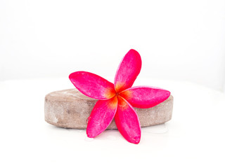 Dark pink frangipani flower placed on the Stone Scrub skin.