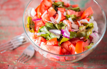 Fresh tomatoes with onion and lettuce in bowl