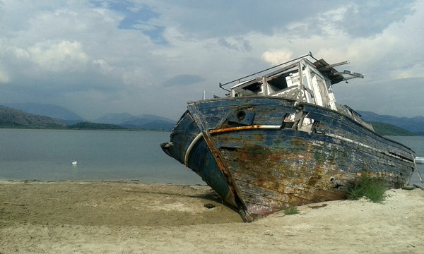 Shipwrecked wood boat on beach	