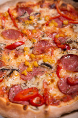 Tasty Italian pizza with pepperoni, corn and mushrooms