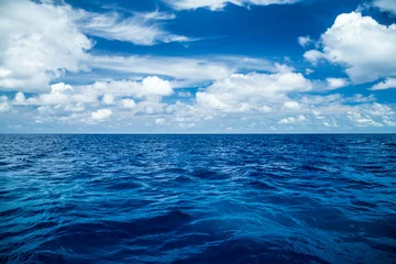 Foto auf Acrylglas Wasser blauer Ozeanhintergrund mit blauem bewölktem Himmel