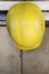 Yellow safety helmet hangs on a shelf