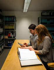 digitalization: young man and woman in the company archives