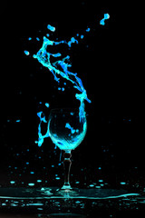 water in wine glasses splash on black background