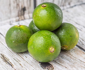 Calamansi citrus over weathered wooden background