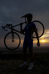 Silhouette of a biker with his bicycle at sunset