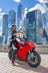 One guy and sexy girl in a suit with a motorcycle sport bike
