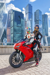 Fototapeta na wymiar One guy and sexy girl in a suit with a motorcycle sport bike