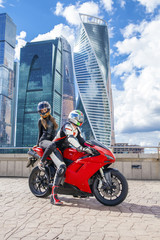 Fototapeta na wymiar One guy and sexy girl in a suit with a motorcycle sport bike