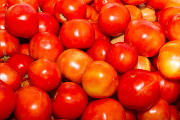 Fresh harvested tomatoes on an open air fruit market stand.
