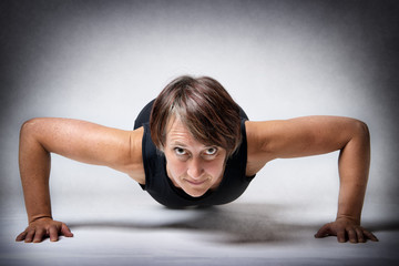 Fototapeta na wymiar Middle aged woman doing push-ups
