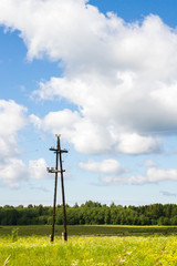 Fototapeta na wymiar Old electric pole in a field in summer