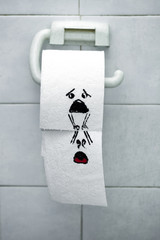 Roll of toilet paper and felt tip pen drawn funny faces