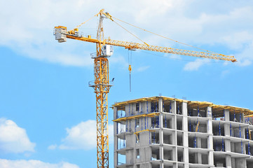 Crane and building construction site against blue sky © Unkas Photo