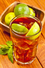 Ice tea with limes are on the brown table.